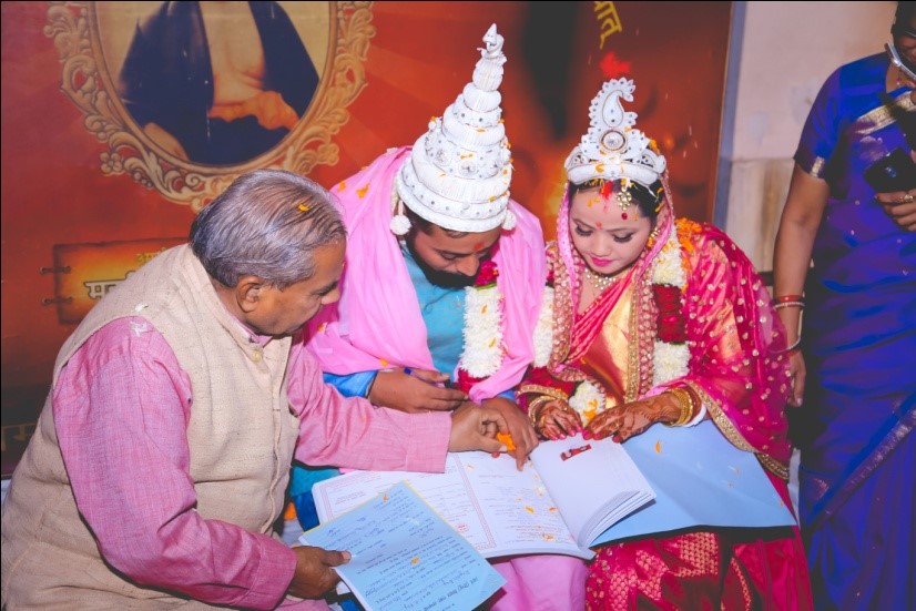 A newly married couple signing the marriage register, India, 2018