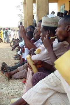 Football spectators snacking on sugarcane at San Siro Stadium, Kaduna, Nigeria, Digital photograph, Ishaq Mohammed Bello