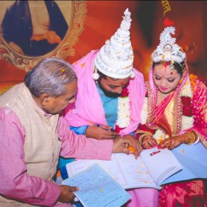 A newly married couple signing the marriage register, India, 2018